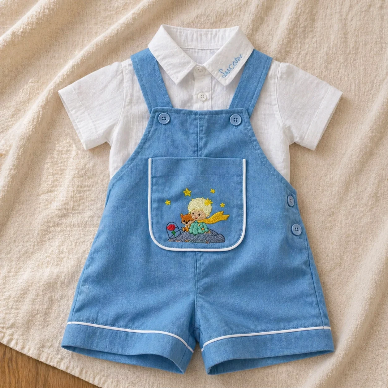 Jardineira Versátil em chambray com camisa branca e bordados tema O Pequeno Príncipe
